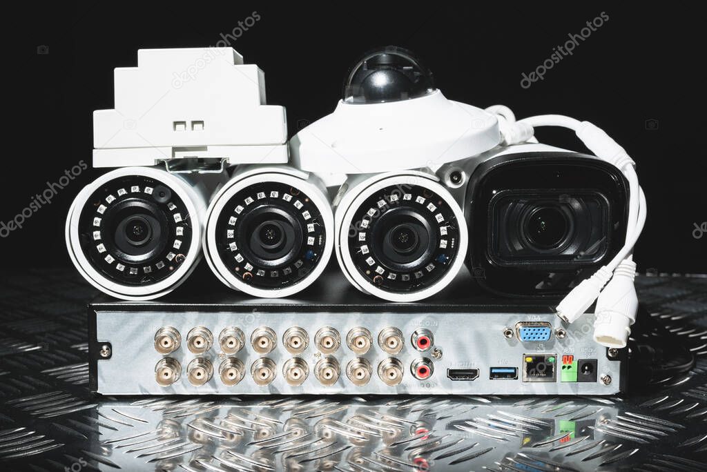 Modern white security cameras and video recorder close up. Video surveillance concept background.