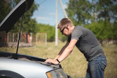 Sürücü, bozuk bir arabanın kaputunu aç..