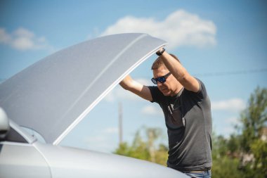 Sürücü, bozuk bir arabanın kaputunu aç..