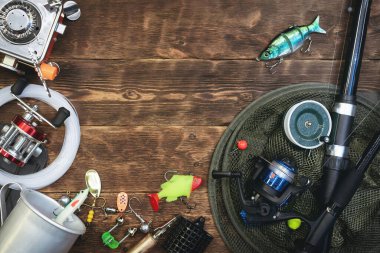 Fotokopi alanı olan düz bir arkaplan. Ahşap bir masada balıkçılık malzemeleri..