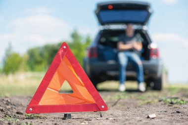 Uyarı üçgeni işareti ve bozuk araba.