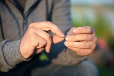Balıkçı yemi oltaya takıyor. Yakından..