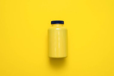 Sarı plastik kavanoz sarı düz arkaplanda yatıyordu..