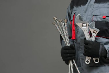 Üzerinde ayarlanabilir anahtarlar ve su hortumları olan bir tesisatçı..