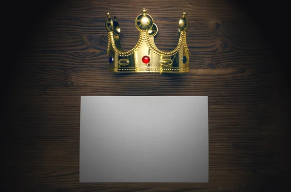 Vip agreement. Premium contract. Special offer. Blank paper sheet and golden crown on wooden table background.