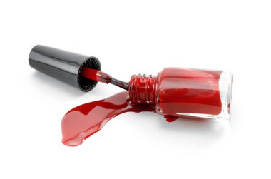 Dökülmüş kırmızı oje şişesi beyaz arka planda izole edilmiş..