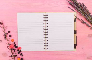 Boş sayfa sayfası olan not defteri, yaban mersini ve kuru lavanta dalları, göz kamaştırıcı mor arka planda fotokopi alanı ile. Liste yapmak için. Hedefler. İpuçları.