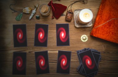 Tarot kartları destesi ve falcı masasının arkasındaki büyü kitabı. Gelecek okuma konsepti.