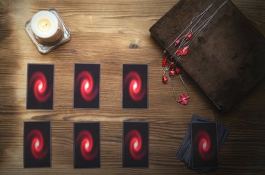 Tarot kartları destesi ve falcı masasının arkasındaki büyü kitabı. Gelecek okuma konsepti.