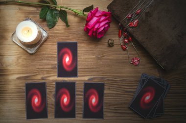 Falcı masasında tarot kartları ve büyü kitabı var. Kehanet kavramını seviyorum.