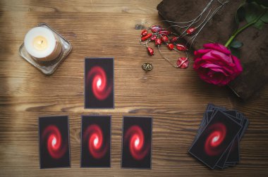 Falcı masasında tarot kartları ve büyü kitabı var. Kehanet kavramını seviyorum.