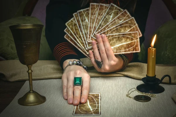Tarot cards on fortune teller desk table. Future reading. Woman fortune teller holding and hands a deck of tarot cards.