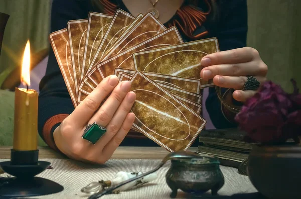 Tarot cards on fortune teller desk table. Future reading. Woman fortune teller holding in hands a deck of tarot cards.