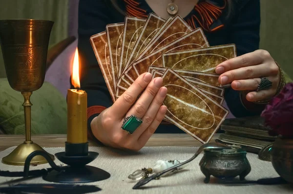 Tarot cards on fortune teller desk table. Future reading. Woman fortune teller holding in hands a deck of tarot cards.