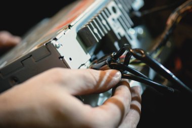 Otomatik elektrikçi bir araba telsiz ses sistemi kuruyor..