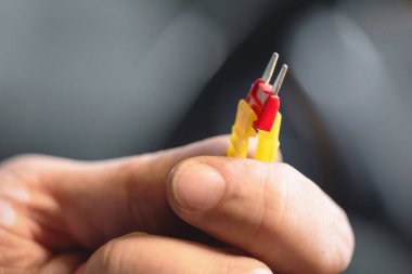 Otomobil elektrikçisinin elinde bir sigorta var. Araba sigortası yenilemesi.