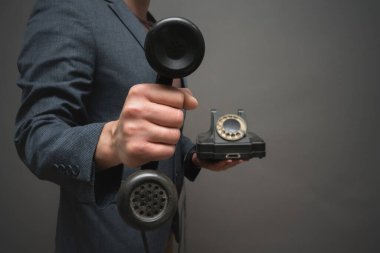 Gri arkaplan üzerine yakın plan insan eli cep telefonu..