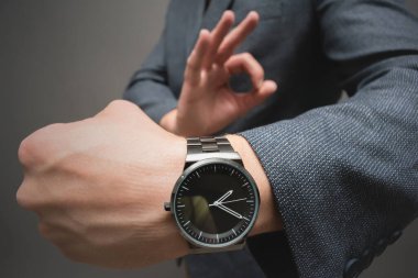 İş adamının elinde bir kol saati var. Yakın plan..
