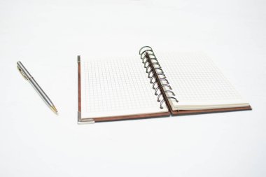 Beyaz masa arka planında boş sayfa not defteri ve kalem.