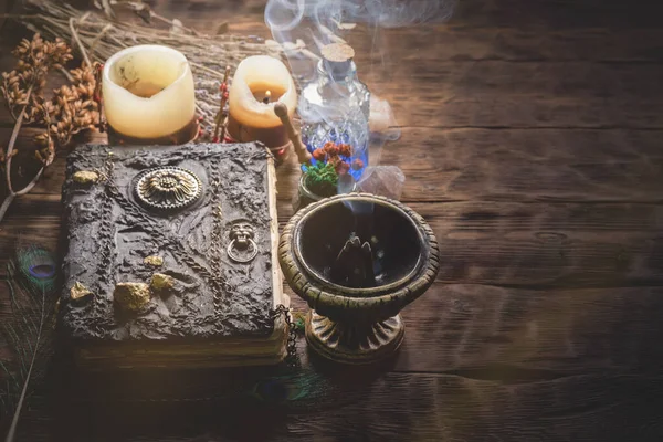 A magic book and potion on the witch doctor table close up.