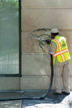 Chicago, IlLINOIS - 31 Mayıs 2019: Şikago Adalet Yürüyüşü sırasında protestocular tarafından yapılan duvar yazılarını yıkayan belediye çalışanı