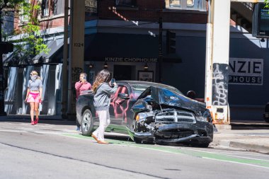 CHICAGO, ILLINOIS - MAY 31, 2019: People making pictures of the car wreckage day after after justice march against police in Chicago clipart