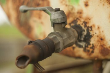 Hava ve hava tarafından aşınmış eski paslı demir musluk.