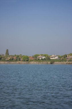 Nehir po ufukta evler ve bitki örtüsü önünde set görebileceğiniz İtalya sularda yapılan dikey atış.