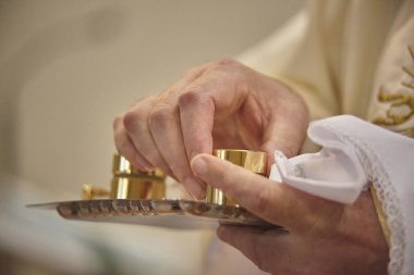 Krom izleri ve catechumens Vaftiz ayini için konteynerler holding rahibin eller.