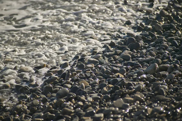 一个小细节的鹅卵石海滩击中海浪坠毁岸边 — 图库照片