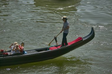 Gondolcu çevresindeki peyzaj fotoğraf isteyen iki turist yürür Venedik