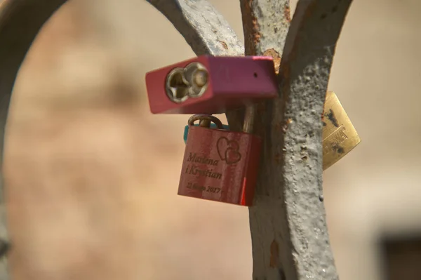 Padlocks with names attached to the bridges of a bridge as a symbol of couple love among boys.