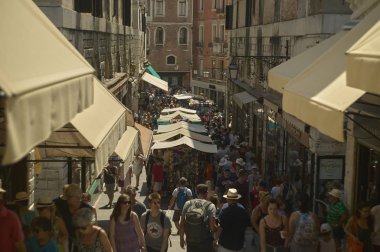 Küçük sokak kalabalık turist ve ziyaret insanlar ile tarihi bir köy. İnsanlarla dolu bir.