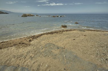 Denize bakan kumsalın içinde kayalar olan bir kısmının detayları..