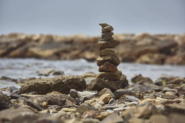 Peace and meditation symbolized by a pile of rocks on the beach: Zen symbol.