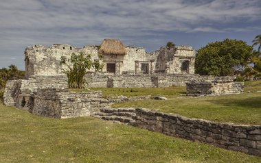 Gün batımında Meksika 'daki Tulum kompleksindeki küçük bir Maya tapınağının yan görüntüsü..
