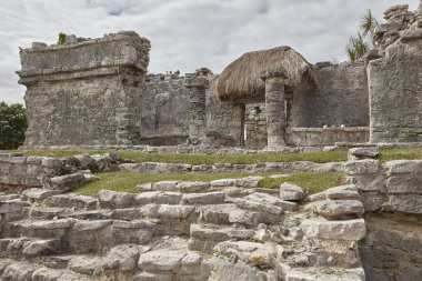 Gün batımında Meksika 'daki Tulum kompleksindeki küçük bir Maya tapınağının yan görüntüsü..