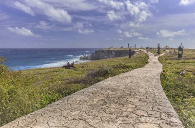 Taştan yol, denizin arka planına sahip yeşil bir bahçeyi geçer: Meksika 'daki Isla Mujeres' deki panorama