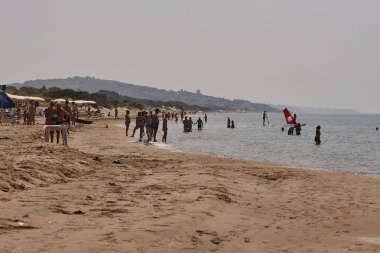 Kumsalda yürüyen insanlar