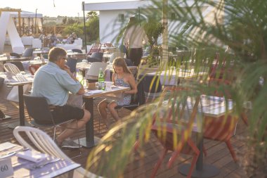 İnsanlar akşam yemeği için bir restoranda oturuyor.
