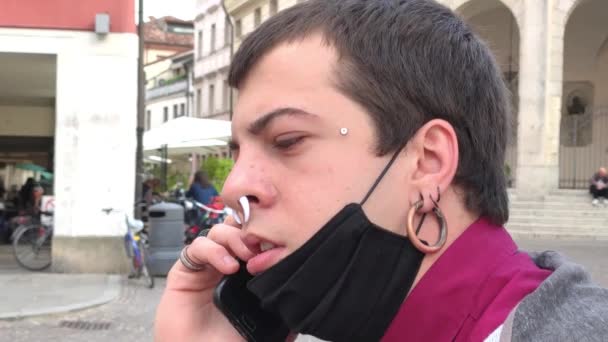 男の子は医療用マスク屋外でスマートフォンで話す — ストック動画