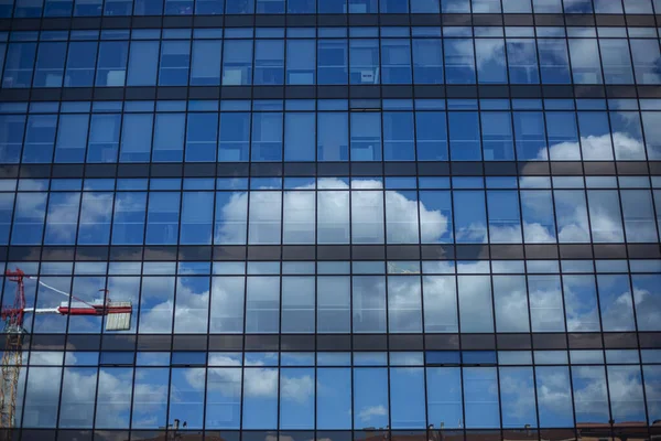 Clouds reflected on a glass modern building in Italy in a sunny day
