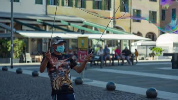 Человек создает мыльные пузыри в городе — стоковое видео