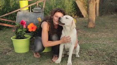 Kız yazın kırsal kesimde Labrador köpeğiyle oynuyor.