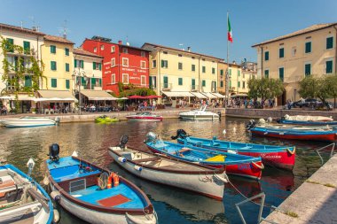 LAZISE, İTALYA 16 Eylül 2020: Lazise 'de Dogana Veneta ve Porticciolo, renkli botlarla