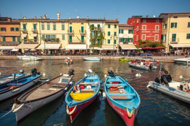 LAZISE, İTALYA 16 Eylül 2020: Lazise 'de Dogana Veneta ve Porticciolo, renkli botlarla