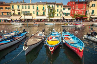 LAZISE, İTALYA 16 Eylül 2020: Lazise 'de Dogana Veneta ve Porticciolo, renkli botlarla