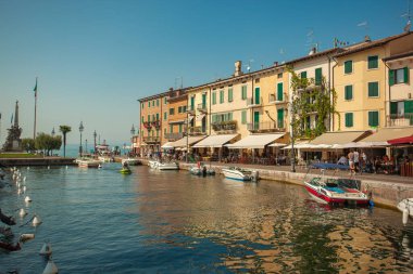 LAZISE, İTALYA 16 Eylül 2020: Lazise 'de Dogana Veneta ve Porticciolo, renkli botlarla