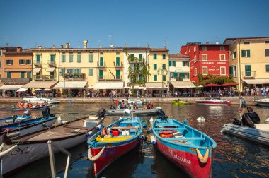 LAZISE, İTALYA 16 Eylül 2020: Lazise 'de Dogana Veneta ve Porticciolo, renkli botlarla