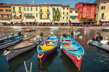 LAZISE, İTALYA 16 Eylül 2020: Lazise 'de Dogana Veneta ve Porticciolo, renkli botlarla